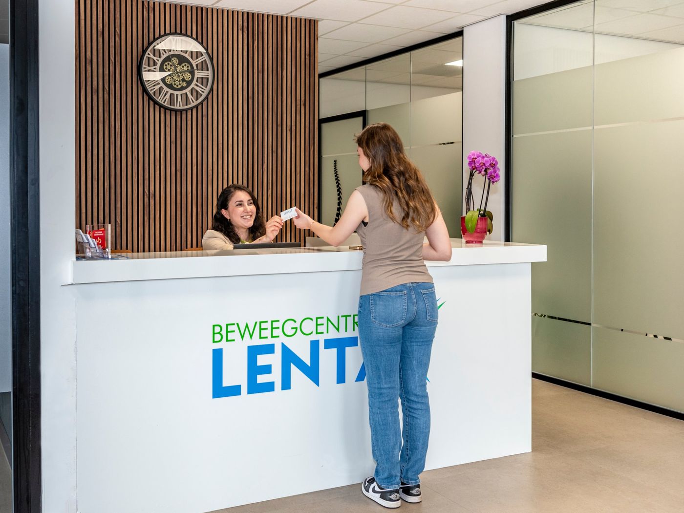 Een patiënt wordt welkom geheten aan de balie van Beweegcentrum Lenta in Arnhem